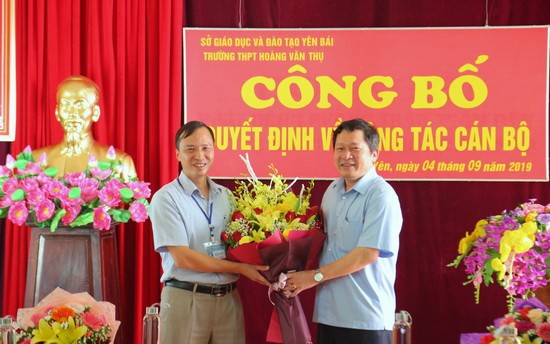 Ông Vương Văn Bằng - Giám đốc Sở GD&ĐT (bên phải) trao quyết định và tặng hoa chúc mừng Hiệu trưởng  Phạm Văn Thư.