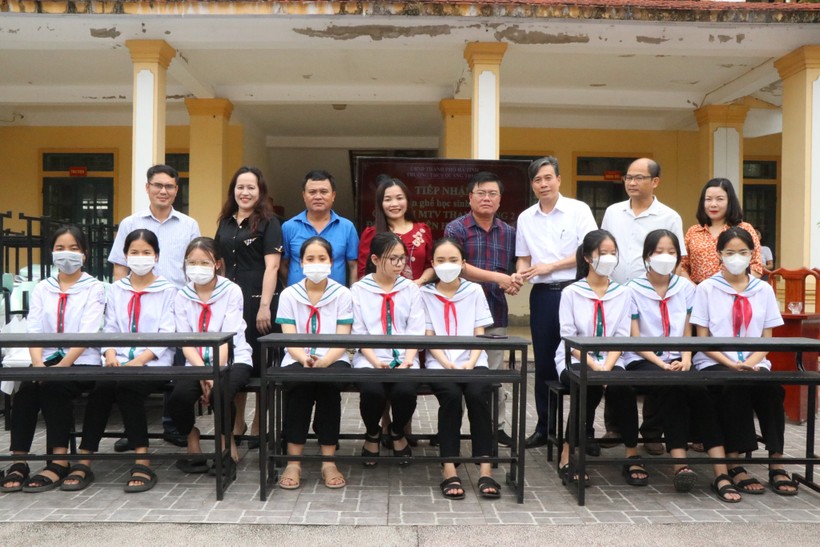 Đại diện Công ty TNHH MTV Thanh Tùng tặng bàn ghế và tủ sách từ nhựa tái chế cho học sinh Trường THCS Quang Trung. (Ảnh: Vũ Long).