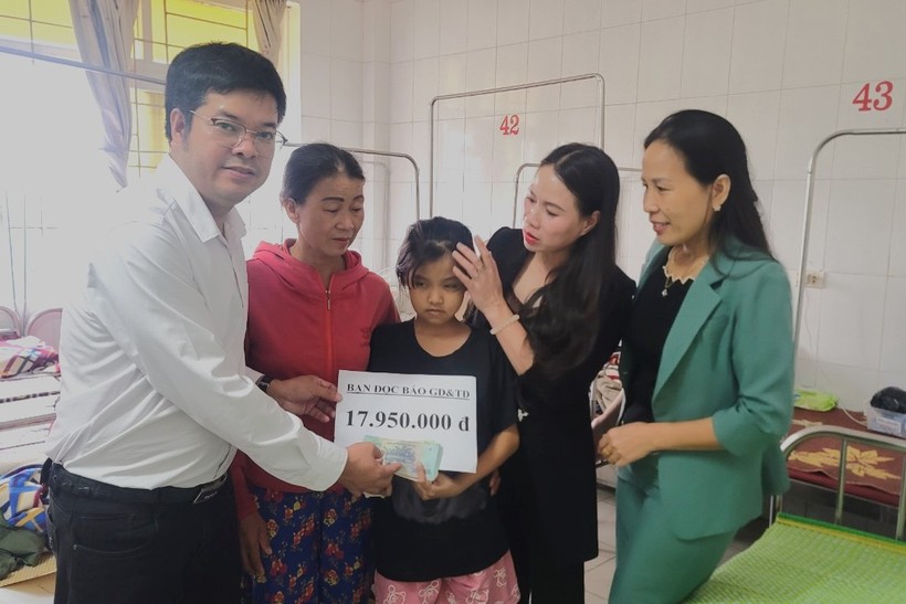 Đại diện Báo GD&TĐ cùng cô Trần Thị Dung Huế (thứ 2 từ phải qua) trao quà bạn đọc đến em Nguyễn Thị Loan.