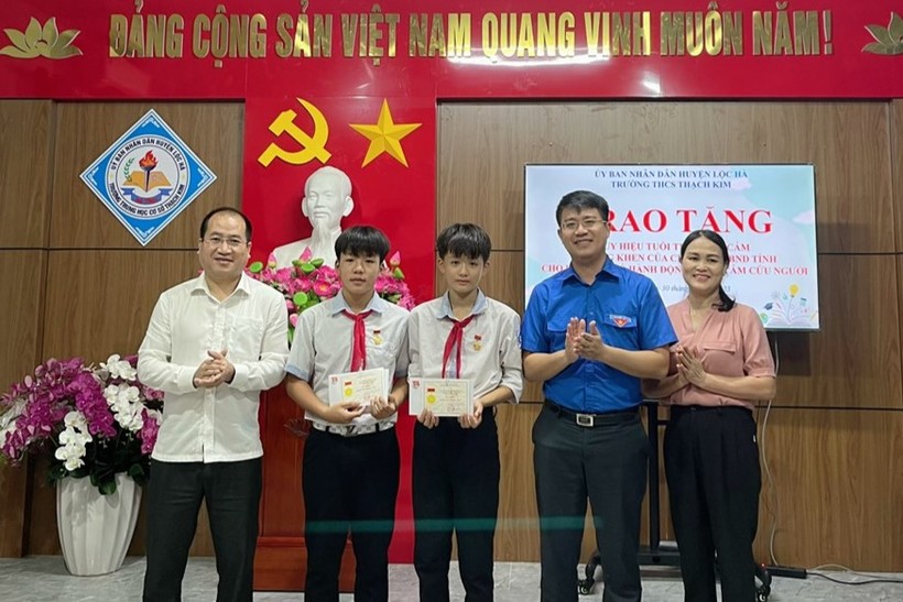 Đại diện Tỉnh đoàn Hà Tĩnh và Huyện ủy Lộc Hà trao huy hiệu Tuổi trẻ dũng cảm cho 2 học sinh Trường THCS Thạch Kim.