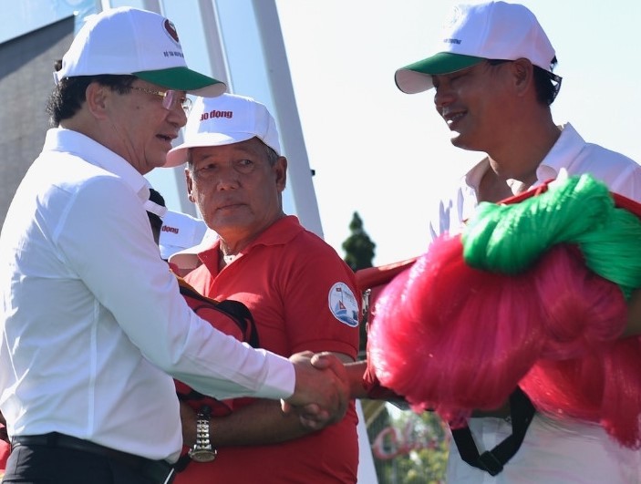 Phó Thủ tướng Trịnh Đình Dũng trao cờ Tổ quốc và lưới đánh cá làm từ nguyên liệu vi sinh thân thiện với môi trường cho ngư dân tỉnh Bạc Liêu (Internet).