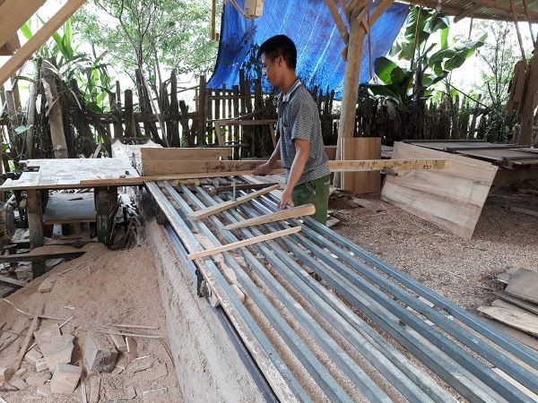 Anh Trương Văn Thủy với chiếc máy xẻ gỗ cải tiến của mình