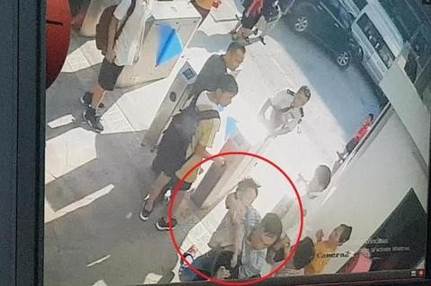 Hình ảnh cắt từ clip ghi lại cảnh cháu bé mặc áo trắng được bế rời khỏi ô tô.