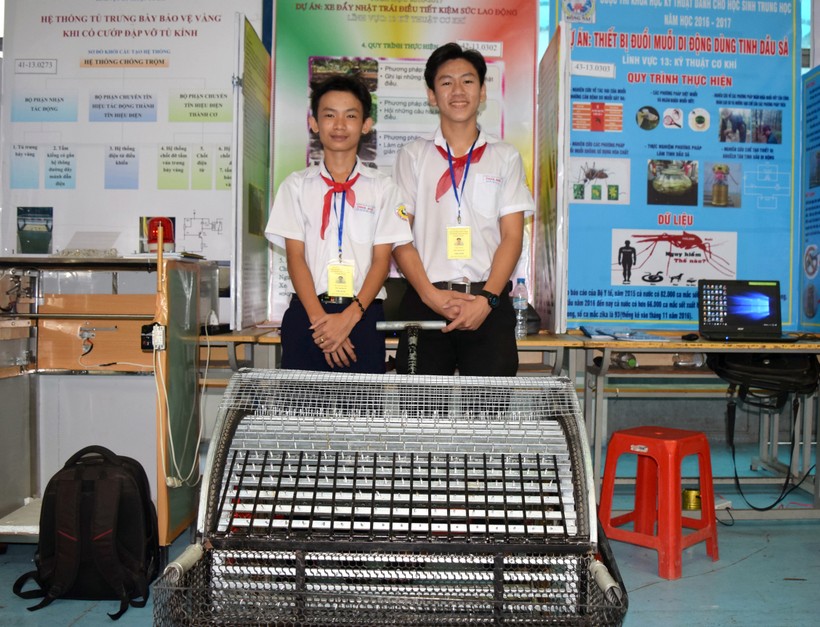 Nguyễn Tiến Đạt (phải) và Trần Nguyễn Đức Thống (trái) bên sản phẩm “xe đẩy nhặt trái điều tiết kiệm sức lao động” 