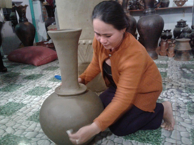 Một nữ nghệ nhân đang tạo dáng một chiếc bình gốm