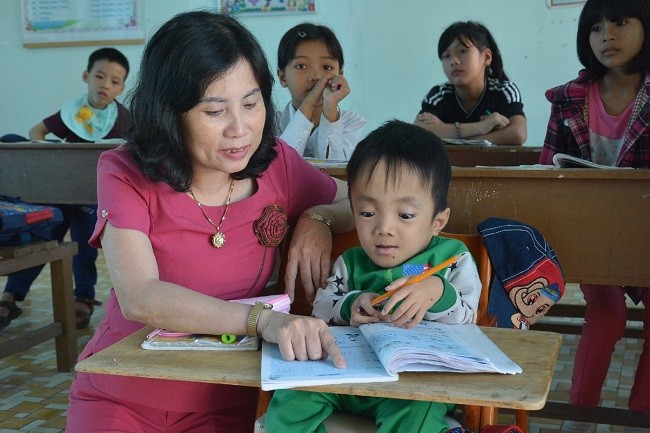 Cô giáo Lương Thị Hồng Phượng đang tận tình chỉ dạy một học sinh khuyết tật