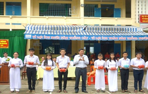Thầy Phạm Văn Mười trao heo đất cho đại diện các Chi đoàn trường