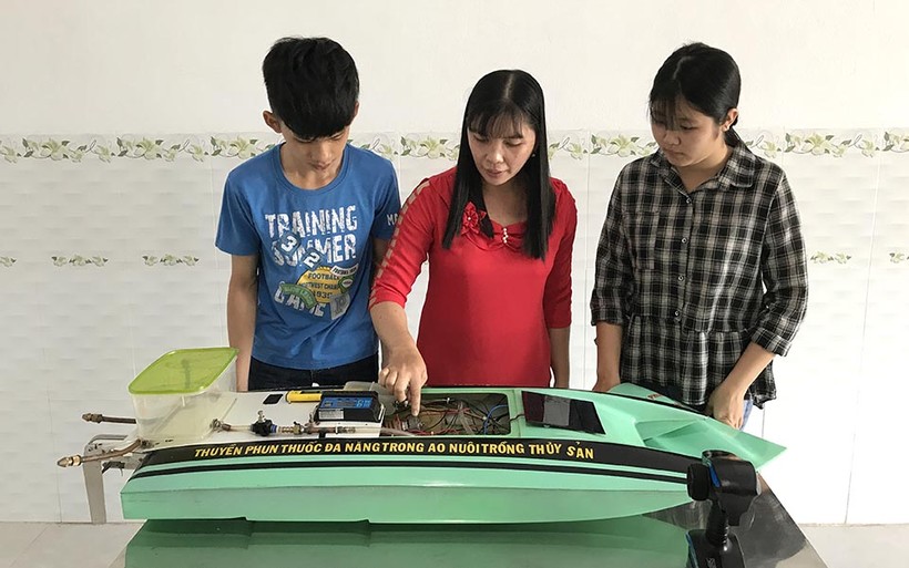 Cô giáo Bùi Thị Ngọc Thúy cùng 2 em Võ Thị Xuân Mai, Ngô Nguyễn Hoàng Anh bên sản phẩm thuyền tự động.