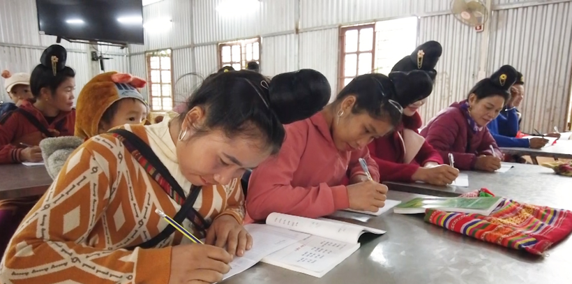 Các học viên đang tập viết chữ tại lớp học.