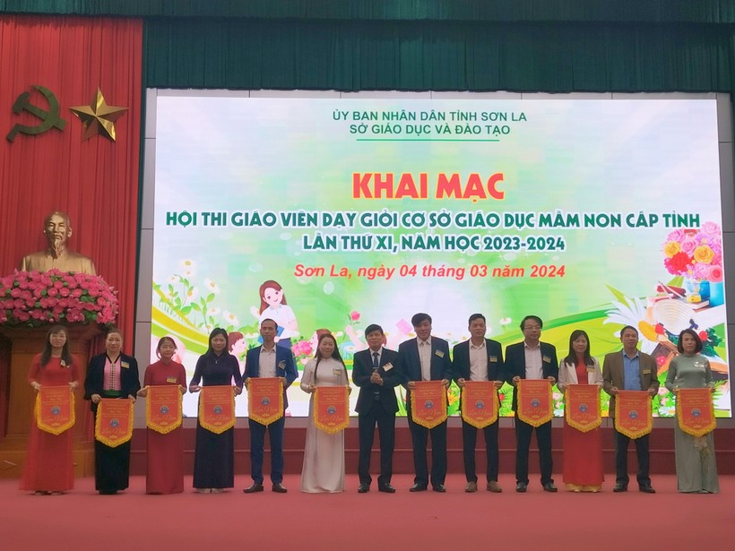 Ông Lê Tiến Quân, Phó Giám đốc Sở GD&ĐT tỉnh Sơn La trao cờ lưu niệm cho trưởng đoàn của 12 huyện, thành phố.