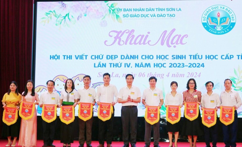 Ông Nguyễn Huy Hoàng, Giám đốc Sở GD&ĐT tỉnh Sơn La trao cờ lưu niệm cho các huyện, thành phố. 