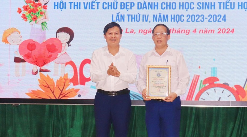 Ông Lê Tiến Quân, Phó giám đốc Sở GD&ĐT (bên trái) trao giải nhất toàn đoàn và giải nhất triển lãm vở sạch - chữ đẹp cho phòng GD&ĐT thành phố Sơn La.