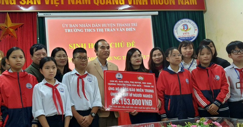 Ông Nguyễn Huy Chương, Chủ tịch UBMTTQ Việt Nam huyện Thanh Trì đại diện tiếp nhận phần quà của thầy trò Trường THCS Thị trấn Văn Điển trao tặng.