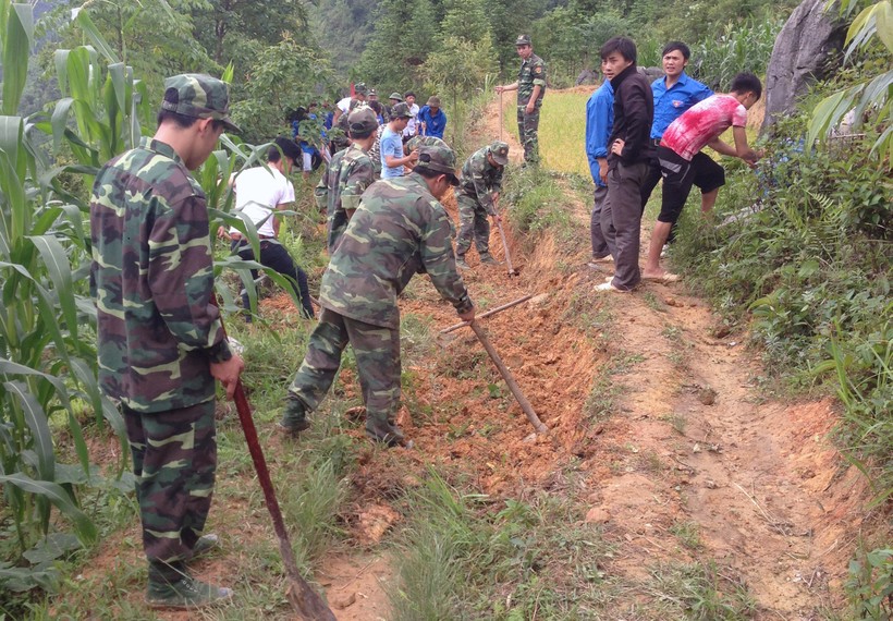 Cán bộ Đồn Biên phòng Xín Mần cùng người dân phát quang đường tuần tra biên giới.