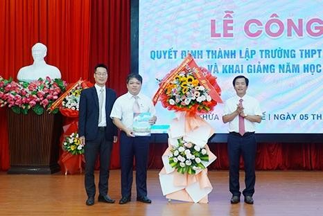 Ông Nguyễn Văn Phương - Chủ tịch UBND tỉnh Thừa Thiên - Huế (bên phải) tặng hoa chúc mừng nhà trường.