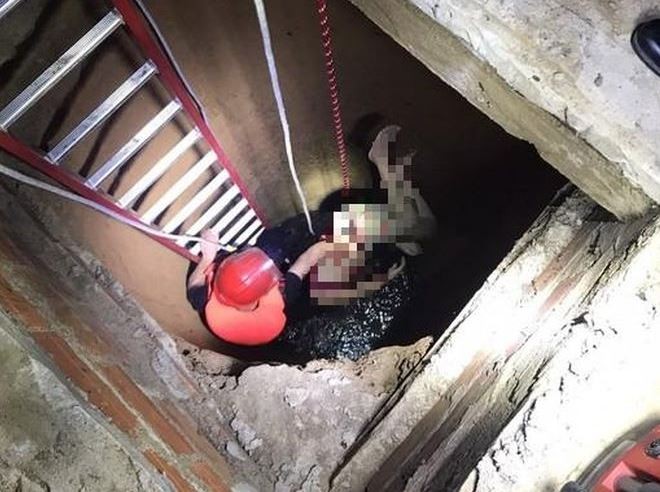 Lực lượng chức năng đưa thi thể người phụ nữ từ dưới giếng lên (Ảnh: CACC)