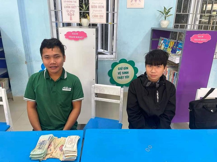 Em Tô Khánh Hoàng Phúc,, học sinh Trường THCS Huỳnh Thúc Kháng, TP Huế (bên phải) nhặt được bọc tiền gần 90 triệu đồng đã tìm trả lại cho anh Lê Văn Duy (bên trái). (Ảnh: T.Đ)