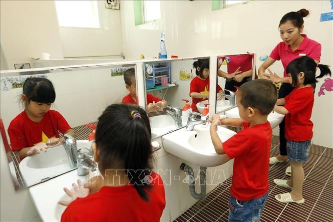 Thực hiện vệ sinh phòng bệnh tay chân miệng cho trẻ trong trường học. Ảnh: TTXVN