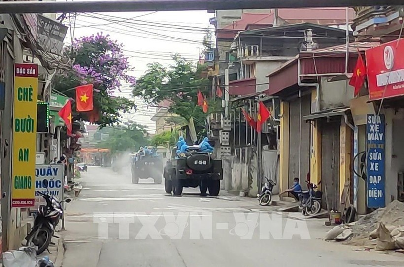 Lực lượng chức năng Bộ Tư lệnh Thủ đô Hà Nội sử dụng xe chuyên dụng phun thuốc khử khuẩn tại xã Tô Hiệu, huyện Thường Tín. Ảnh: TTXVN phát