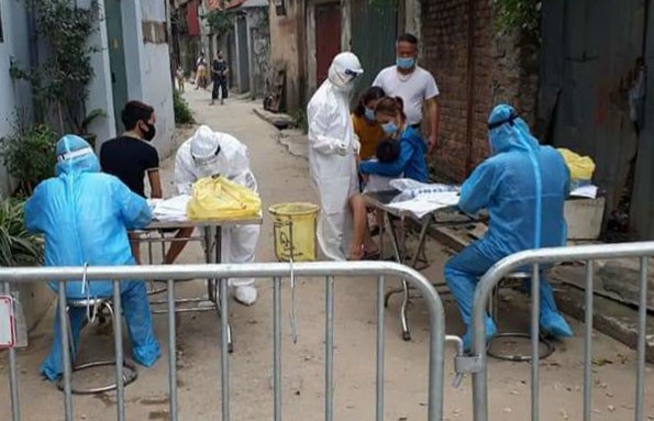 Nhân viên y tế lấy mẫu xét nghiệm SARS-CoV-2 cho người dân xã Hiệp Thuận. Ảnh: HNM