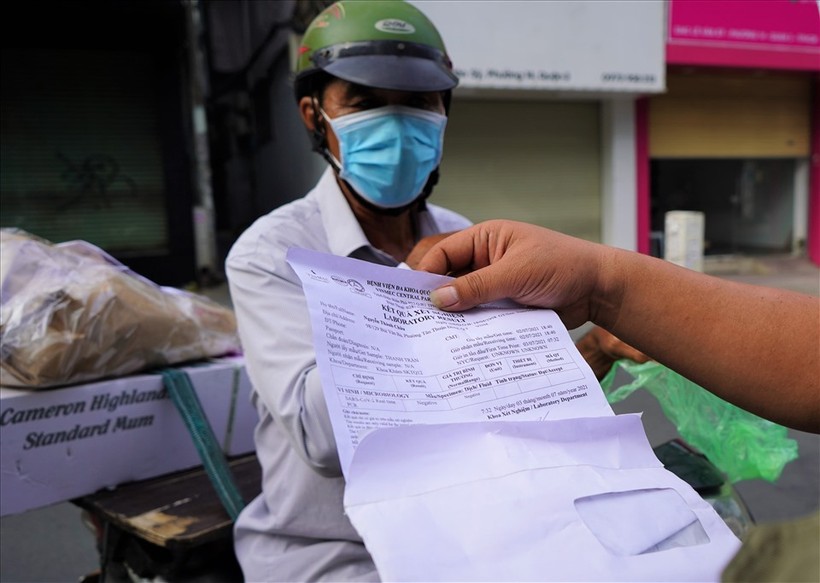 Cán bộ công an đang kiểm tra giấy tờ của người dân tại chốt trên đường Lê Văn Sĩ, Quận 3 trong chiều 9/7. Ảnh: LĐO.
