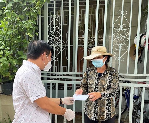 Người lao động nghèo ở quận Gò Vấp nhận tiền từ gói hỗ trợ của TP Hồ Chí Minh. Ảnh: Minh Khang.