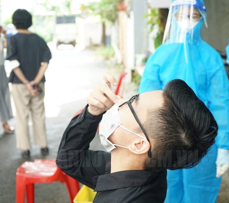 Người dân tự lấy mẫu với sự hướng dẫn của nhân viên y tế. Nguồn: Trang tin điện tử Đảng Bộ TP Hồ Chí Minh.
