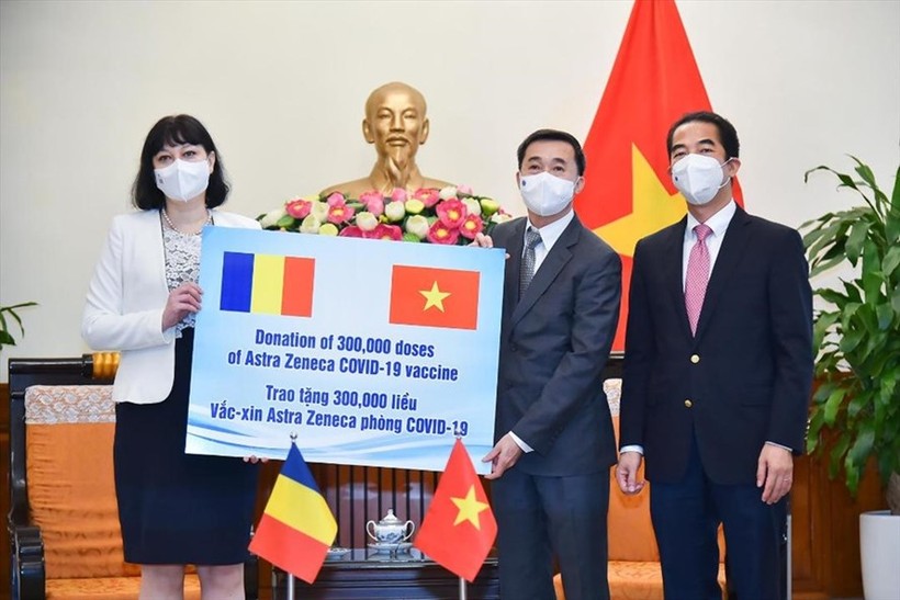 Thứ trưởng Ngoại giao Tô Anh Dũng (phải), Thứ trưởng Bộ Y tế Trần Văn Thuấn (giữa) tiếp nhận tượng trưng 300.000 liều vắc xin Romania trao tặng. Ảnh: BNG.