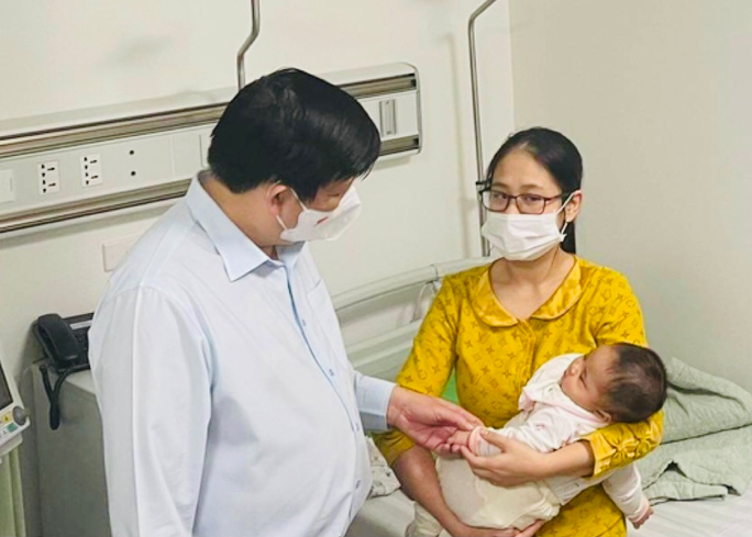 Lãnh đạo Bộ Y tế trò chuyện với gia đình cháu bé bị tiêm nhầm vắc-xin theo dõi sức khỏe tại Bệnh viện Xanh Pôn - Ảnh: T.Q.