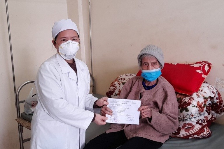 Cán bộ y tế huyện Hữu Lũng trao giấy ra viện cho cụ bà Nông Thị Phít. Ảnh: Trung tâm y tế huyện Hữu Lũng.