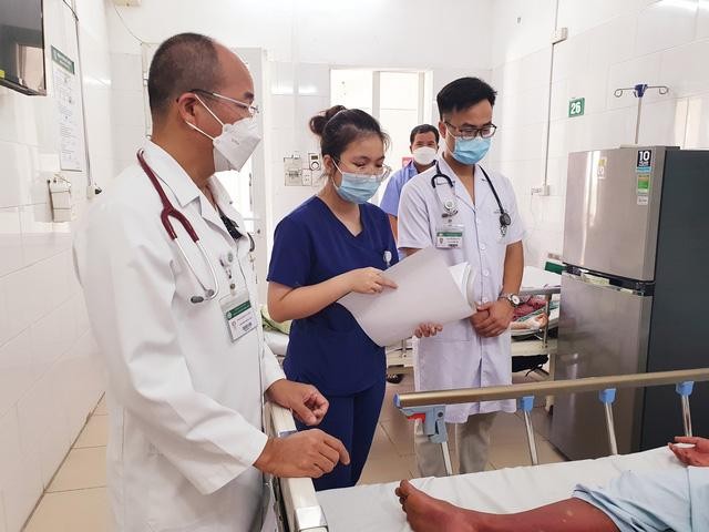 Các bác sĩ Trung tâm Bệnh nhiệt đới thăm khám cho bệnh nhân sốt xuất huyết đang điều trị tại Trung tâm. Ảnh: BV.