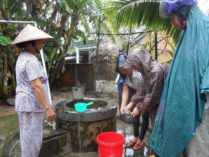 Cán bộ y tế hướng dẫn cách xử lý nước an toàn vệ sinh thực phẩm, đảm bảo sức khỏe cho người dân trong mùa mưa bão, lũ lụt. Ảnh: Thùy Vy.