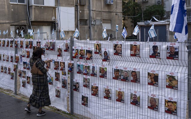 Một người phụ nữ xem những bức ảnh các con tin bị bắt ở Gaza được treo ở Ramat Gan, ngày 22/1/2023