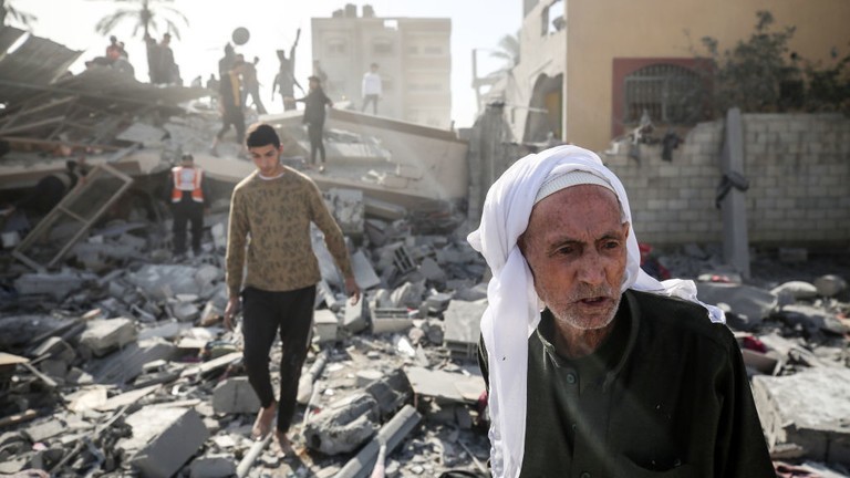 Người Palestine đi qua đống đổ nát của một ngôi nhà bị phá hủy sau vụ đánh bom của Israel hôm 22/12/2023 ở trung tâm Dải Gaza 