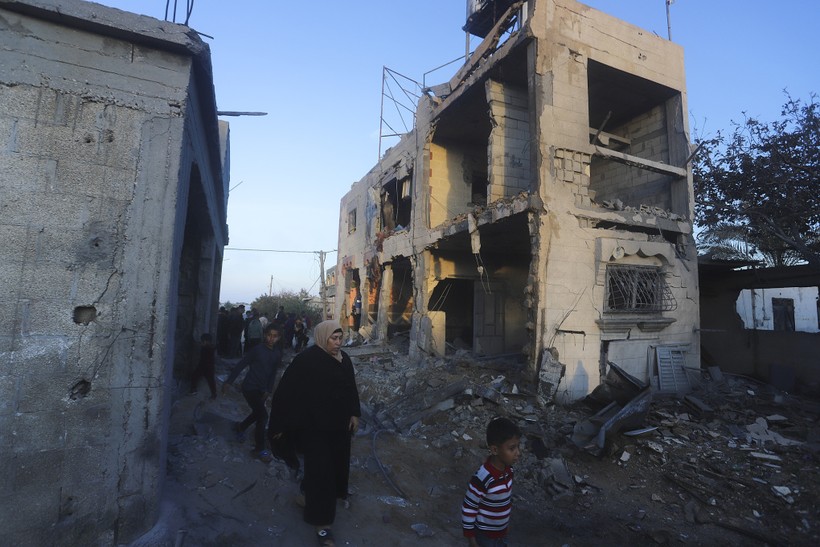 Người Palestine đi ngang qua tòa nhà đổ nát sau đợt không kích của Israel vào Rafah, ngày 12/2/2024