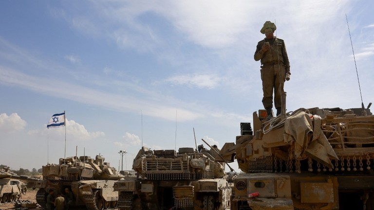 Một người lính Israel đứng trên xe tăng trong doanh trại quân đội gần biên giới Israel với Gaza