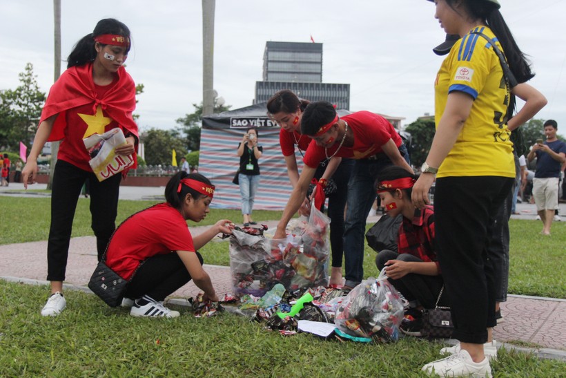 Nhiều bạn trẻ nán lại nhặt rác tại Quảng trường Hồ Chí Minh sau khi trận bóng kết thúc