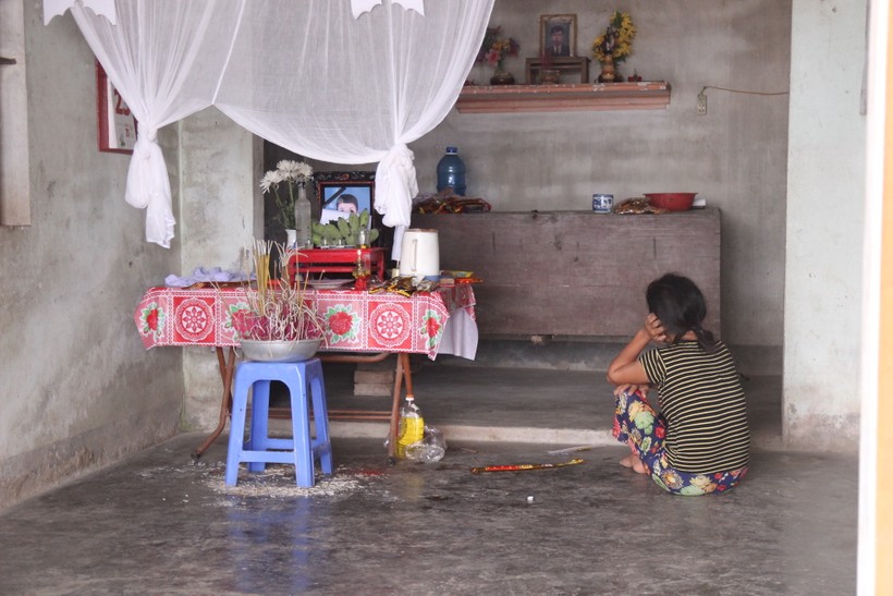 Người mẹ nghèo ngồi bất động trước di ảnh con là em Nguyễn Gia Tiến (HS Trường THPT Nguyễn Cảnh Chân).
