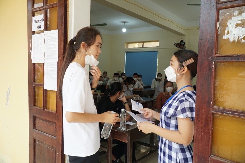 Giám thị kiểm tra thông tin thí sinh trước khi vào phòng thi tại điểm thi Trường THPT Phạm Hồng Thái (huyện Hưng Nguyên, Nghệ An).
