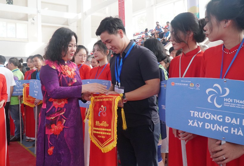 Thứ trưởng Bộ GD&ĐT Ngô Thị Minh trao cờ lưu niệm cho đại diện các đơn vị tham gia hội thao.