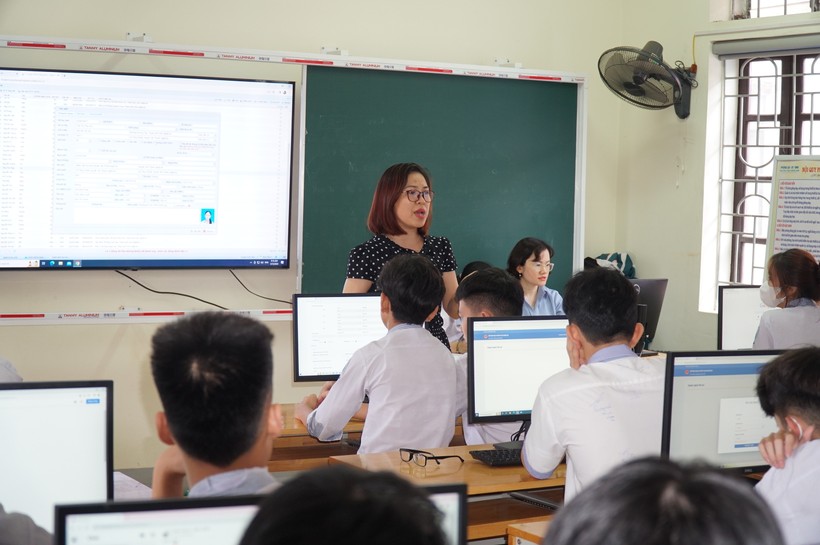 Các giáo viên Trường THCS Hồng Sơn (TP Vinh, Nghệ An) hướng dẫn và hỗ trợ học sinh đăng ký tuyển sinh vào lớp 10 bằng hình thức trực tuyến. Ảnh: Hồ Lài.