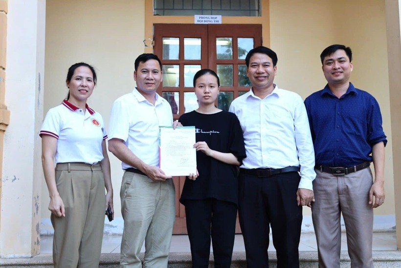 Đại diện Trường ĐH Kinh tế Nghệ An trao quyết định trúng tuyển (có điều kiện) và các chính sách học bổng cho em Hoàng Thị Hải Yến. Ảnh: NTCC.
