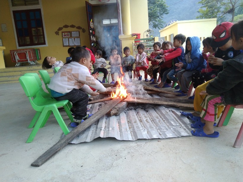 Trẻ sưởi ấm trong giờ ra chơi tại điểm bản Piêng Cọc, Trường Mầm non Mai Sơn (huyện Tương Dương, Nghệ An). Ảnh: NTCC