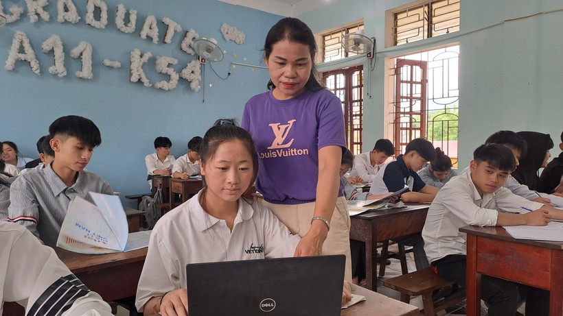 Em Và Thị Thanh (lớp 12A11, Trường THPT Quế Phong, Nghệ An) được giáo viên hướng dẫn đăng ký dự thi tốt nghiệp THPT năm 2024 hình thức trực tuyến. Ảnh: Ngô Chiến Thắng