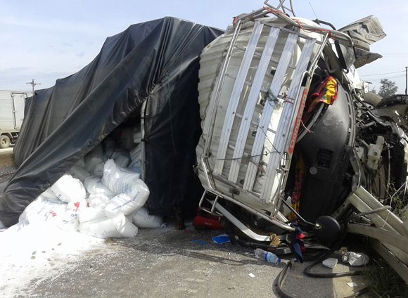 Chiếc xe tải bị đâm nát bét, nhiều thùng hạt nhựa rơi xuống đường