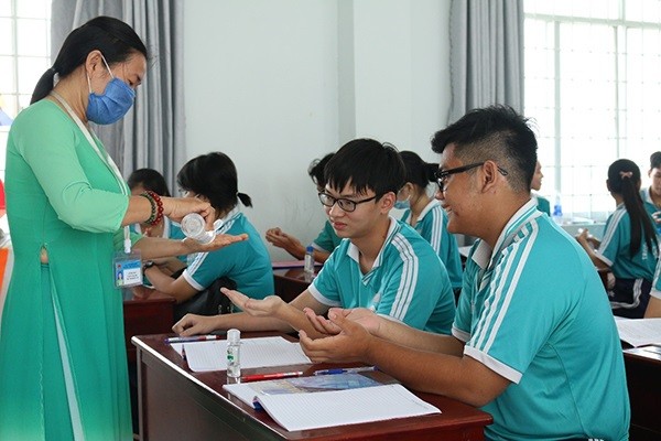 Học sinh ở Kiên Giang được giáo viên hướng dẫn sử dụng dung dịch sát khuẩn đúng cách để phòng dịch Covid-19. Ảnh: ITN