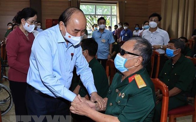 Chủ tịch nước Nguyễn Xuân Phúc thăm hỏi thương bệnh binh tại Trung tâm nuôi dưỡng bệnh binh nặng và Điều dưỡng người có công tỉnh Hà Nam. Ảnh: TTXVN.