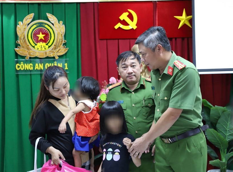 Lực lượng chức năng trao trả hai cháu bé về với gia đình. (Ảnh: TTBC-HCM)