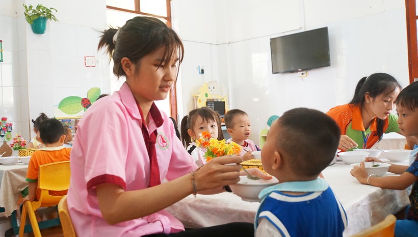 Trần Thị Diễm Quỳnh, sinh viên thực tập tại Trường Mầm non Thạnh An, cho trẻ ăn sáng. Ảnh: Mạnh Tùng