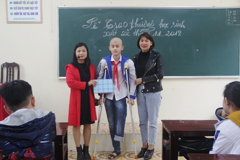 Lê Minh Quang, học sinh lớp 8A, trường THCS Minh Khai (TP. Thanh Hóa) được cô giáo chủ nhiệm trao phần thưởng của lớp. Ảnh: Hồng Đức